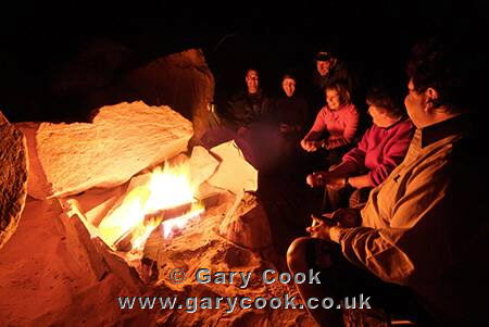 Group sitting around the campfire, bush camp in the Sahara Desert, Libya