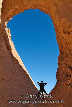 Tourists exploring a natural arch, Jebel Acacus, Sahara Desert, Libya