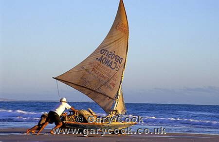Fisherman pushing his boat out to sea, Canoa Quebrada beach, Ceara, north east Brazil