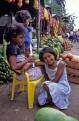 Young girls at fruit stalls, near Santo Domingo de los Colorados, Ecuador